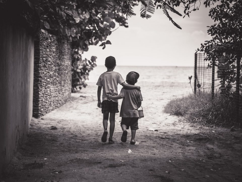 grayscale photography of child and toddler while walking