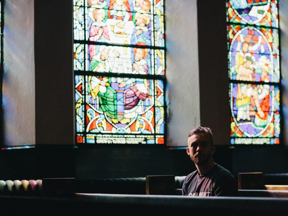 man sitting on pew chair